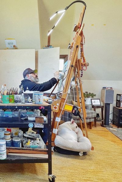 Canadian contemporary realism artist Brandon Steen workingat his easel in his studio.