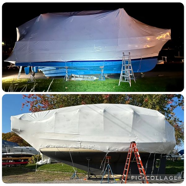 Two boats wrapped in protective shrink wrap with ladders beside them.