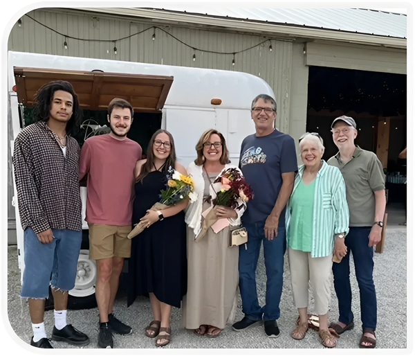 Family group posing by a white camper