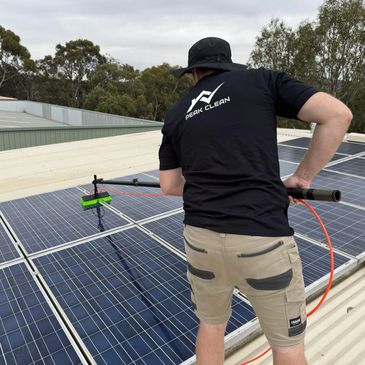 Peak Clean technician cleaning rooftop solar panels with specialised equipment to maximise efficienc