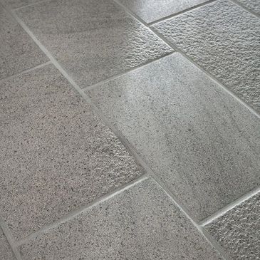 Close-up of textured gray stone tiles arranged in a grid pattern.