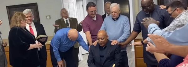 Group praying together in a room.
