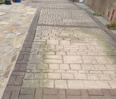 An image of a driveway that has become dirty with moss and algae.
