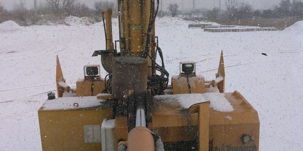 Snow-covered construction equipment on a snowy day.