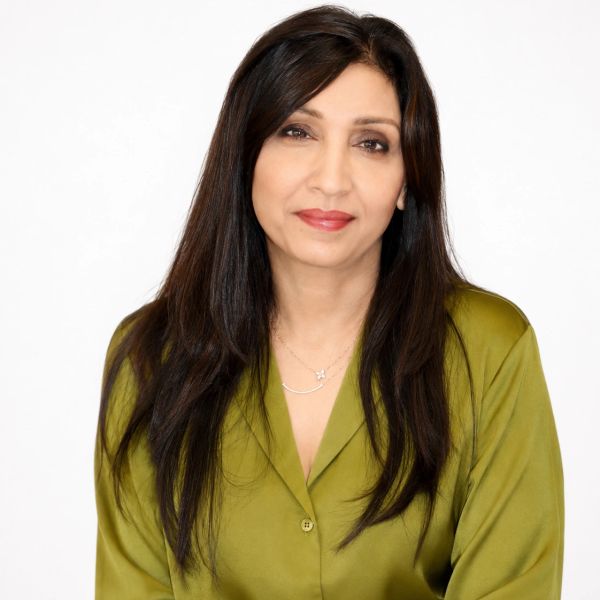Woman with long dark hair wearing a green blouse, smiling gently.