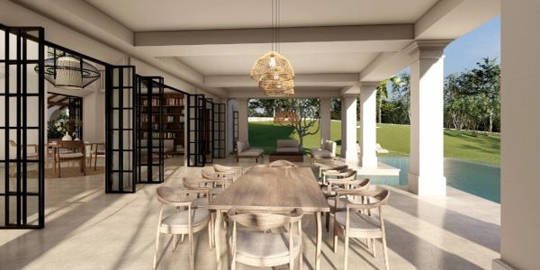 Spacious outdoor dining area with wooden furniture and poolside view.
