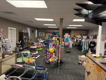 A colorful kids' play and clothing store with toys and outfits.