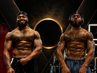 Two muscular men posing shirtless in a gym with black and gold decor.