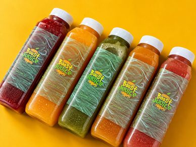 Five colorful Boost Juice bottles arranged on a yellow background.