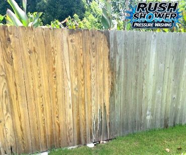 Fence partially pressure washed, showing a bright clean side and a dirty side.