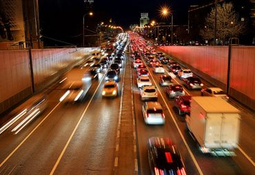 A busy highway at night, with traffic in both directions blurring by.