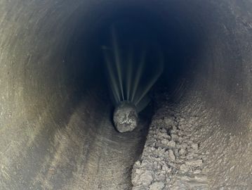 View inside a pipe clogged with debris and dirt.