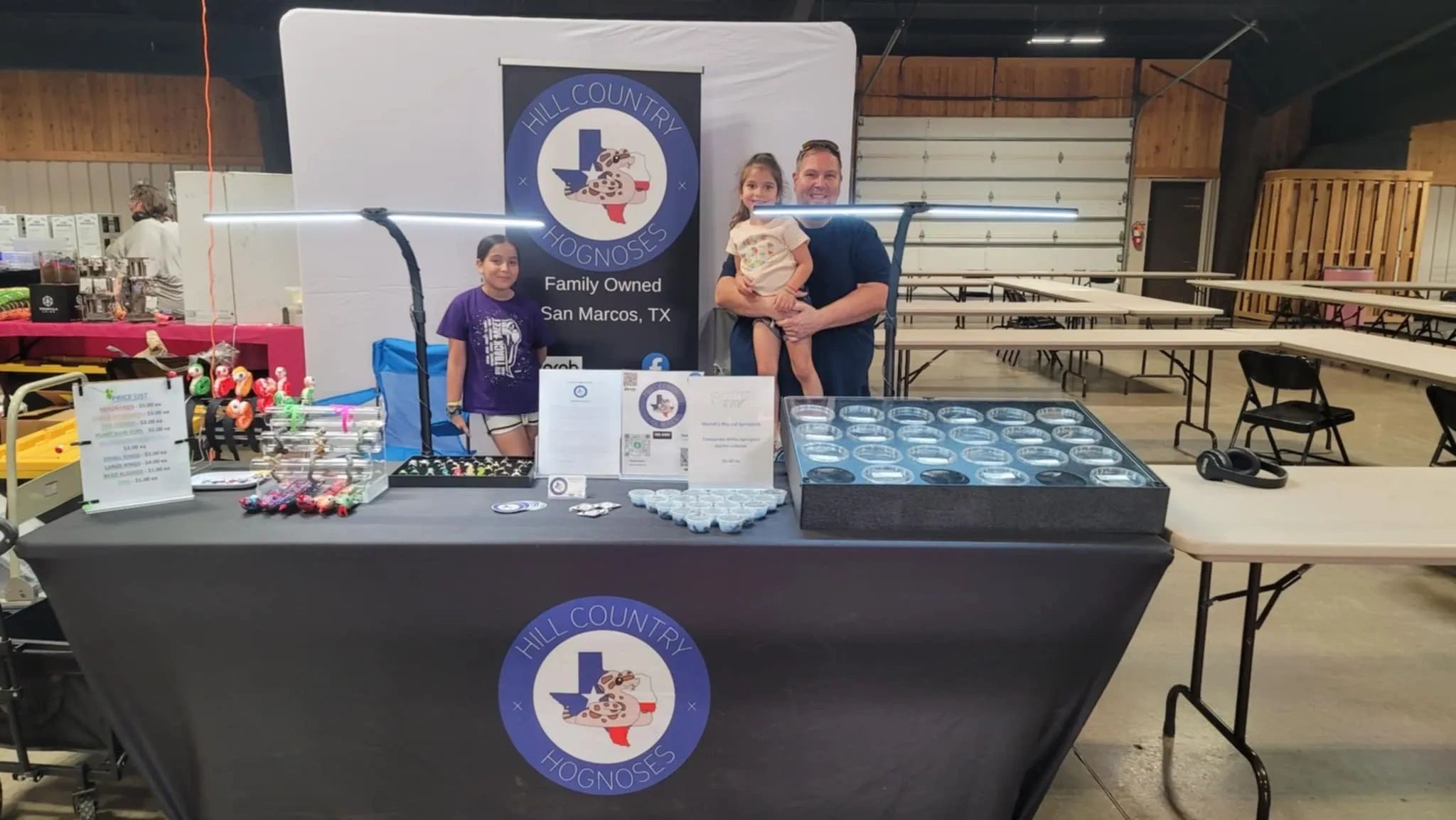 Family-run Hill Country Hognoses booth with reptiles and merchandise in San Marcos, TX.