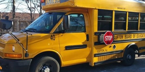 Yellow mini school bus with stop sign extended.