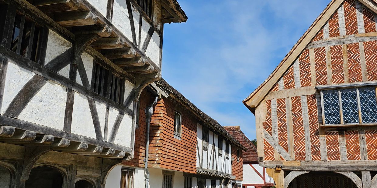 Traditional timber-framed buildings under a clear blue sky.
