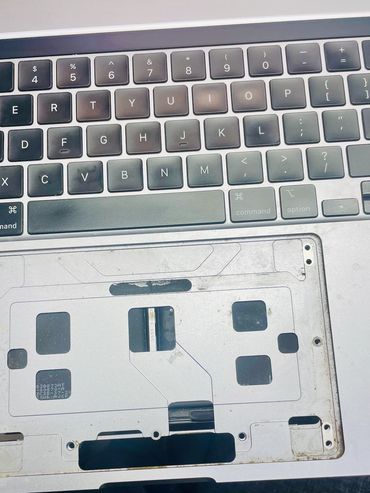 Close-up of a laptop keyboard missing its trackpad.