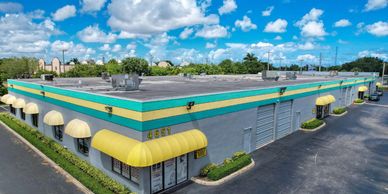 A colorful commercial building with yellow awnings under a bright blue sky.