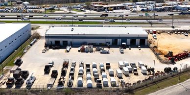 Aerial view of an industrial building with parked trucks and vehicles.