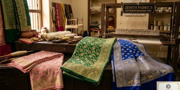 Colorful Banarasi fabrics displayed in a traditional weaving workshop.