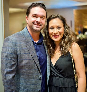 Smiling couple posing for a photo indoors.