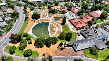 Aerial view of a park with ponds and buildings.