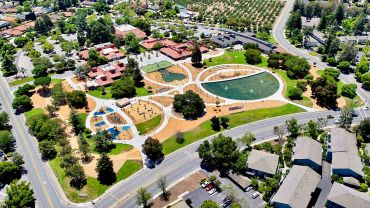 A large community park with playgrounds, water features, and walking paths.