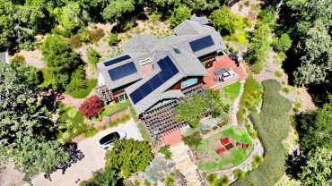 Aerial view of a house with solar panels on the roof.