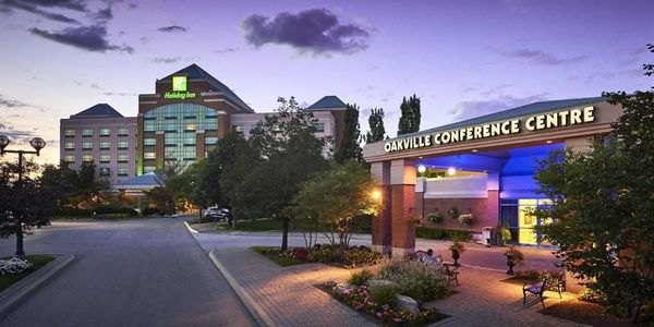 Holiday Inn Oakville Conference Centre at dusk with illuminated signage.
