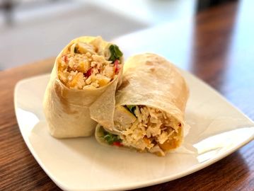 A delicious wrap cut in half on a white plate.