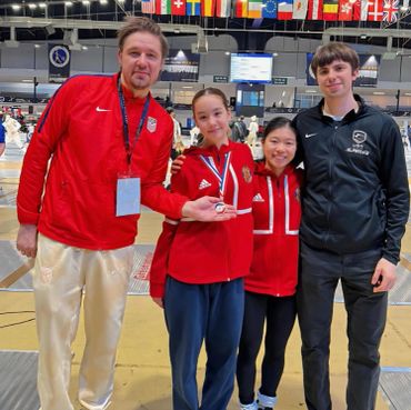 Coaches Alex and Ethan with fencers with medals at world cup.