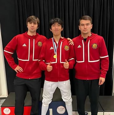 Coaches Ethan and Akhmad with fencer and medal.