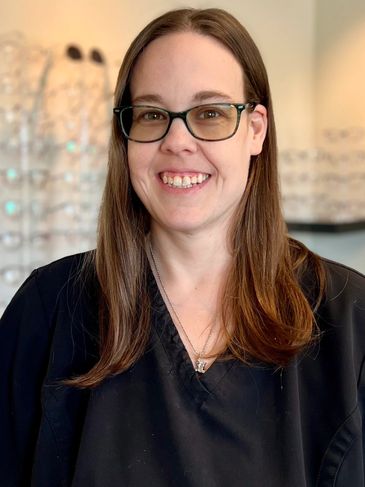 Smiling woman with glasses in a professional setting.