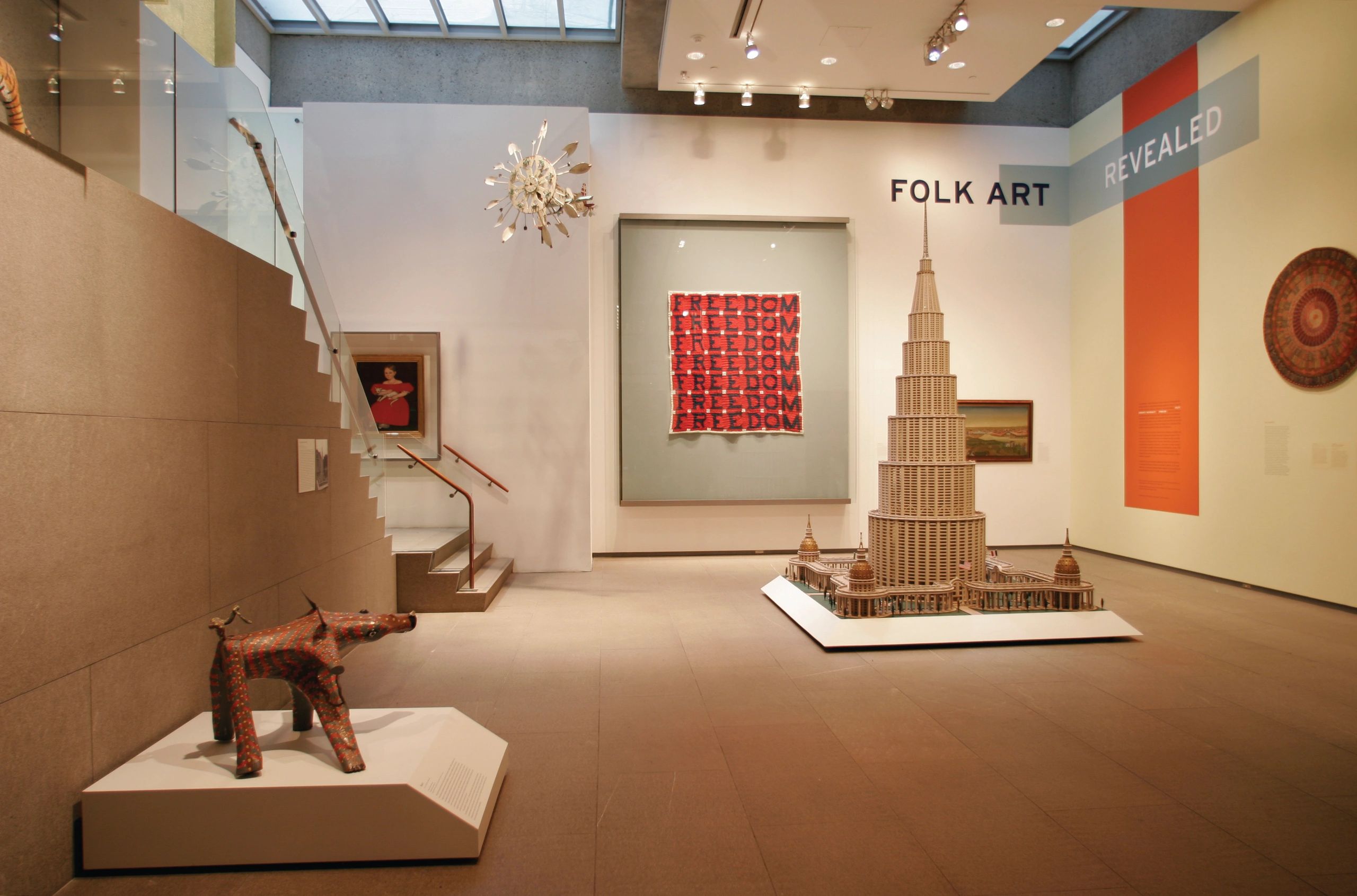 Museum exhibit showcasing folk art with sculptures and paintings.