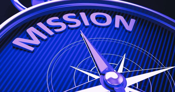 A compass needle pointing towards the word 'MISSION' on a blue background.