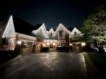 A home in Halton Hills illuminated with bright white permanent outdoor LED lighting along the roof.
