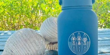 Rubber-finish blue water bottle with surfing girls—Souvenirs section color photo.