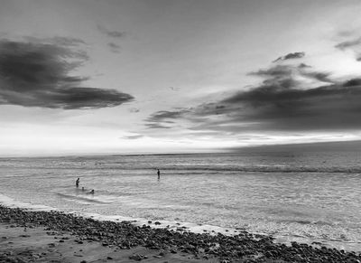 Beach scene with swimmers and cloudy sky—black and white photo of Playa La Saladita.