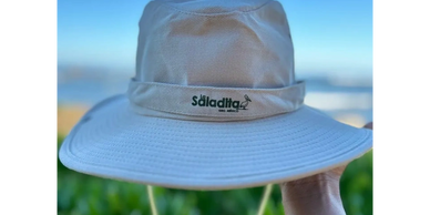 Safari hat with “Saladita” and surfing pelican—Souvenirs section color photo.