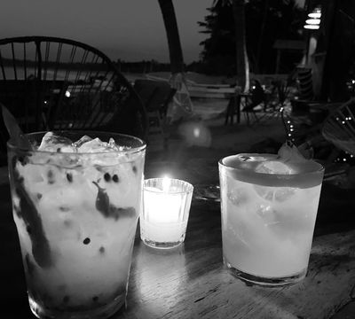Black and white photo of two margaritas—passion fruit and classic—on a table overlooking the ocean at Marea restaurant, Playa La Saladita.