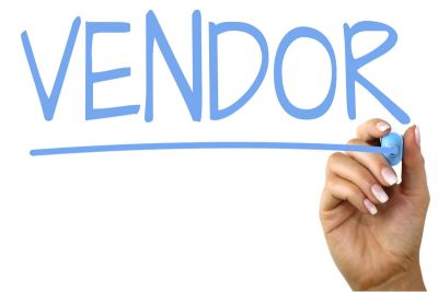 Hand writing the word 'VENDOR' in blue marker.