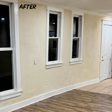 Renovated room with new wood flooring and freshly painted walls.