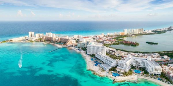 Aerial view of a coastal resort city with turquoise waters and hotels.