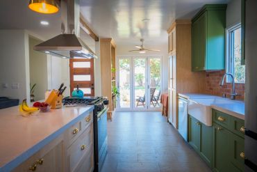 Bright kitchen with green cabinets and natural light.