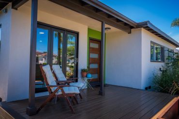 Cozy porch with wooden chairs and modern front door.
