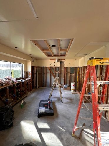 Room under construction with ladders and tools.