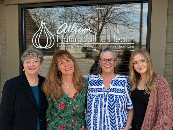 Four women smiling outside Allium Naturopathic Health clinic.