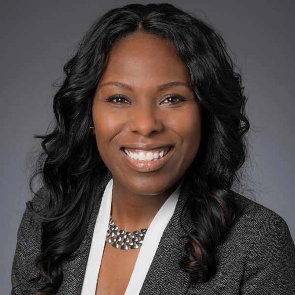Professional woman smiling confidently in business attire.