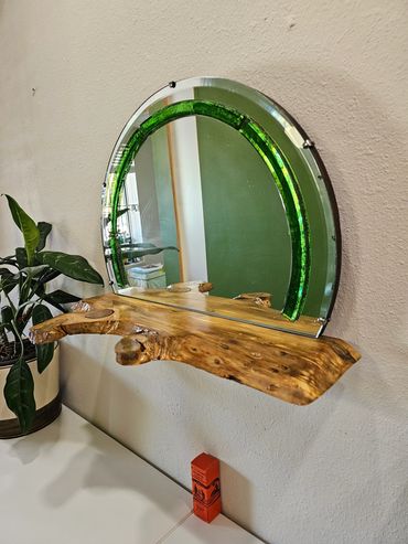 Vintage mirror with green glass trim, complemented by a holly-type wood shelf.