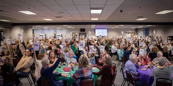 People holding up numbered signs in a large room.
