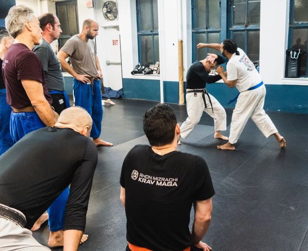 People practicing Krav Maga self-defense techniques in a training session.